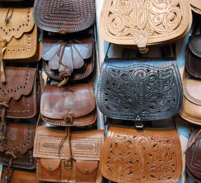 A bunch of leather bags are lined up together